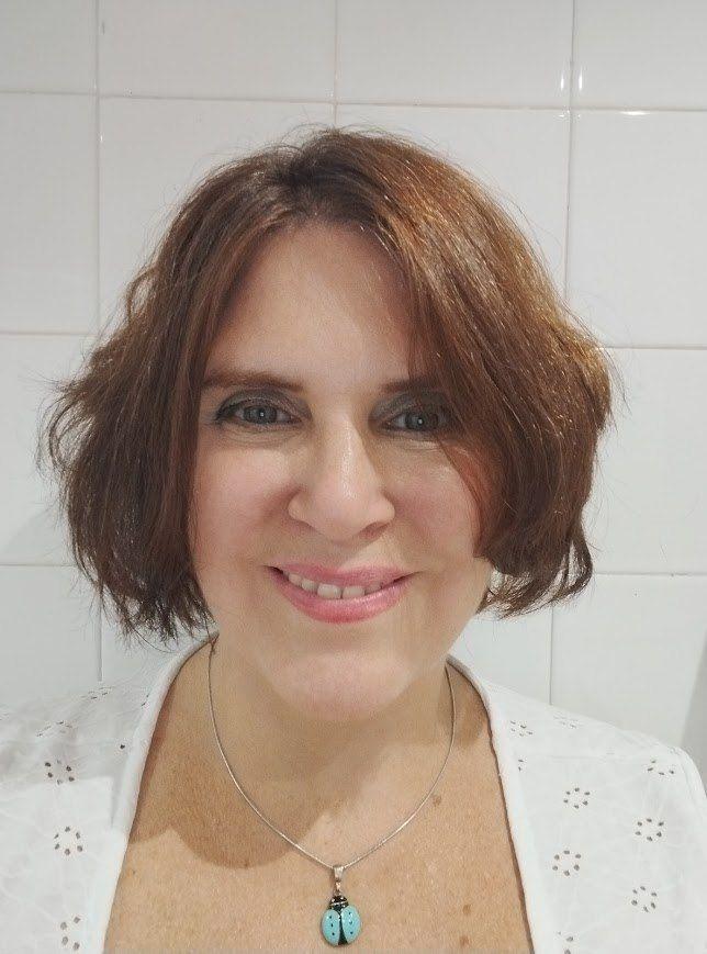 Primer plano de Romina Navarro, mirando de frente a la cámara. Romina tiene tez blanca y cabellos castaños, cortos, lacio pero con movimiento.